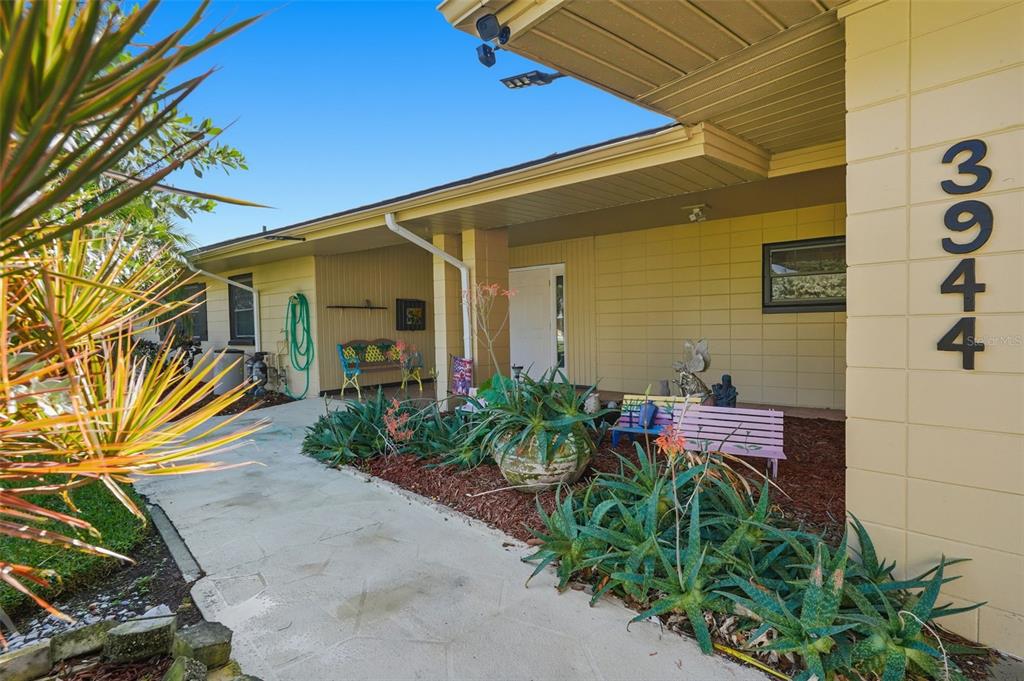 A concrete walkway leads to the covered front porch of a single-story house — 3944 49TH AVENUE S, ST PETERSBURG, FL