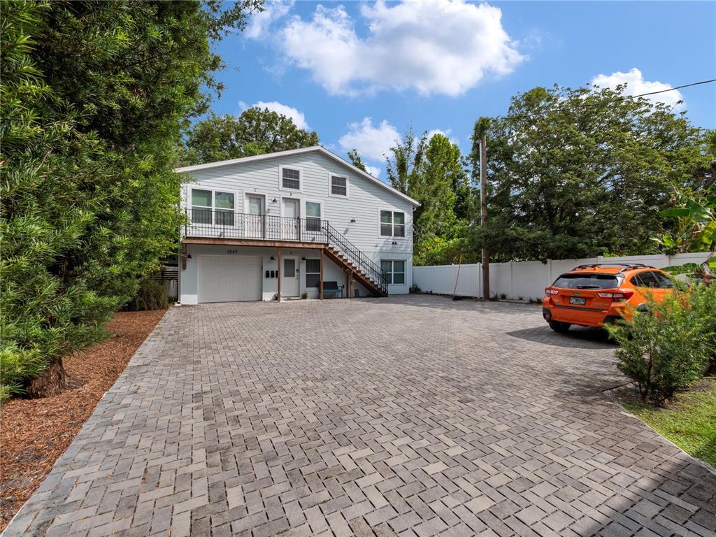 A two-story light blue house features a paved driveway, a garage, and an exterior staircase — 1505 CATHERINE STREET, ORLANDO, FL