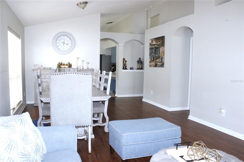 A dining area with a table and chairs sits adjacent to a living room space — 10228 HUNTERS HAVEN BOULEVARD, RIVERVIEW, FL