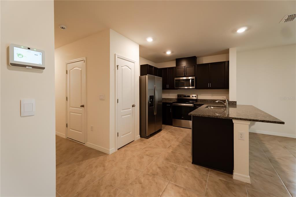 A kitchen with dark cabinets, stainless steel appliances, and a granite-topped island — 2331 GIFFORD DRIVE, DAVENPORT, FL