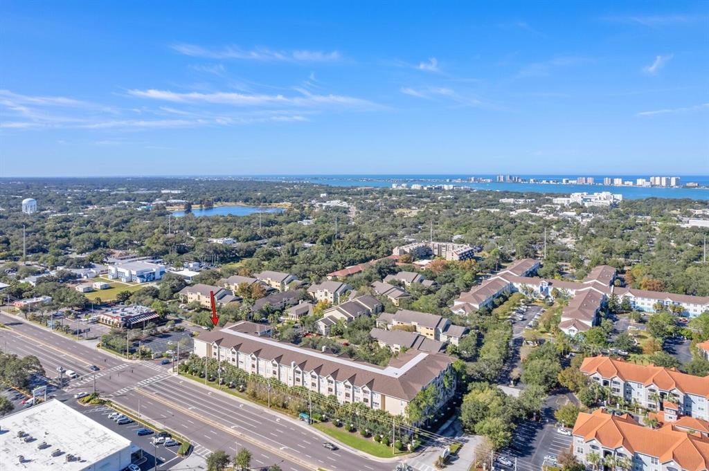 An aerial view shows a multi-story apartment complex situated along a busy multi-lane road — 1216 S MISSOURI AVENUE UNIT 226, CLEARWATER, FL