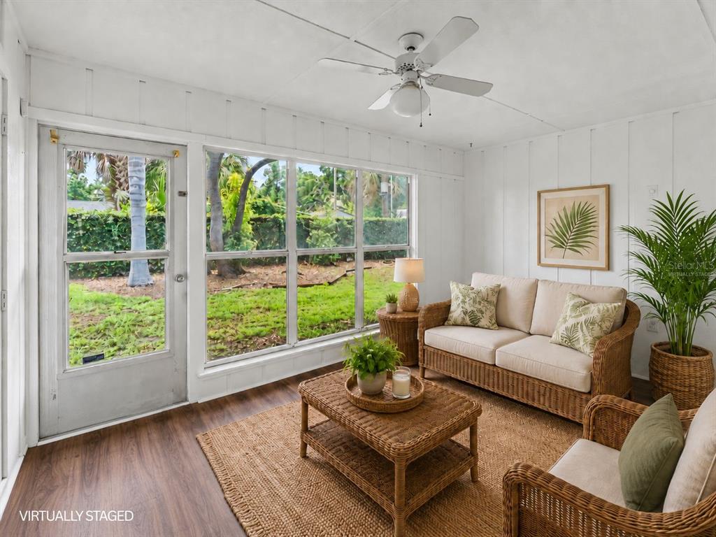 A sunroom with white paneled walls, a ceiling fan, and wicker furniture overlooking a yard — 2025 SYLVESTER RD UNIT C1, LAKELAND, FL