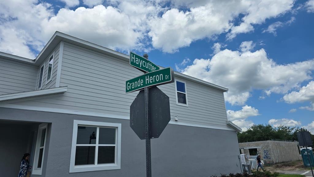 A street sign for Haycutter and Grande Heron Drive stands in front of a house — 3323 GRANDE HERON DRIVE, ST CLOUD, FL