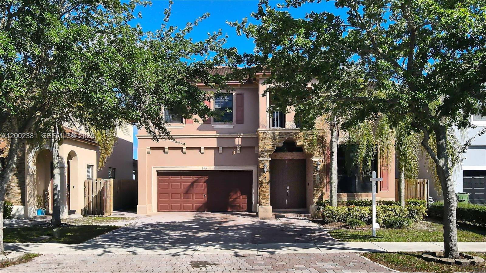 A two-story suburban house with a two-car garage and stone accents on the front facade — 685 SE 37th Pl, Homestead FL 33033, HOMESTEAD, FL