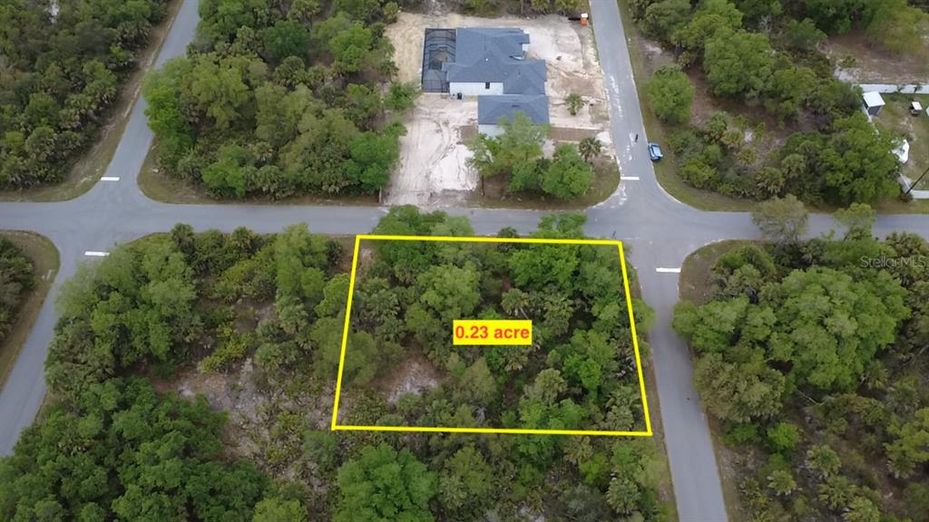 This aerial view shows a vacant, wooded residential lot outlined in yellow — 18125 GARTH AVENUE, PORT CHARLOTTE, FL
