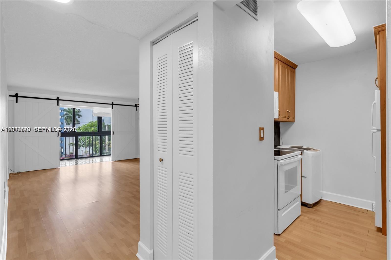 A view from a kitchen looking toward a living area with sliding barn doors — 5055 NW 7th St # 504, Miami FL 33126, MIAMI, FL