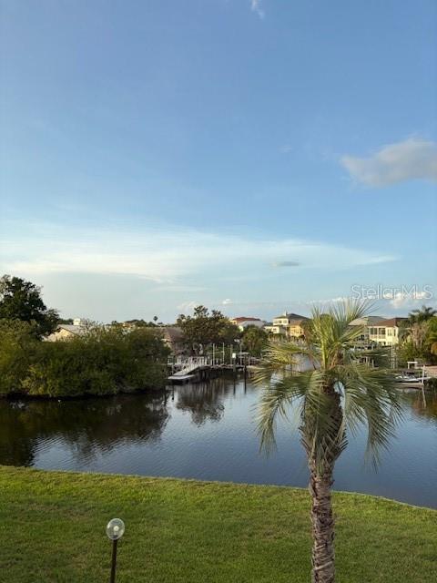 A view of a calm waterway with a palm tree in the foreground — 4609 MARINE PARKWAY UNIT 203, NEW PORT RICHEY, FL