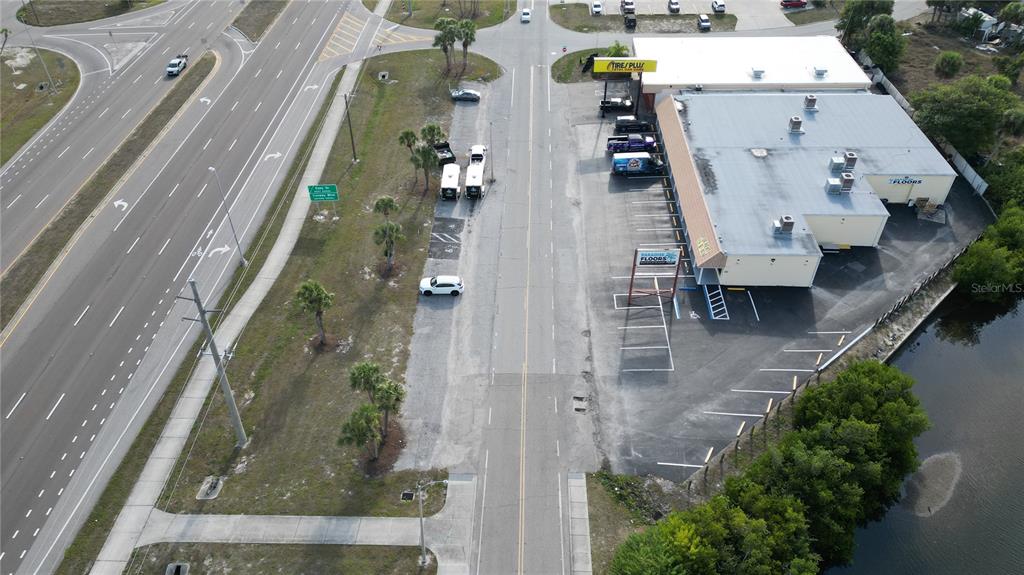 An aerial view shows a commercial building with a parking lot next to a road — 3527 TAMIAMI TRAIL UNIT E, PORT CHARLOTTE, FL