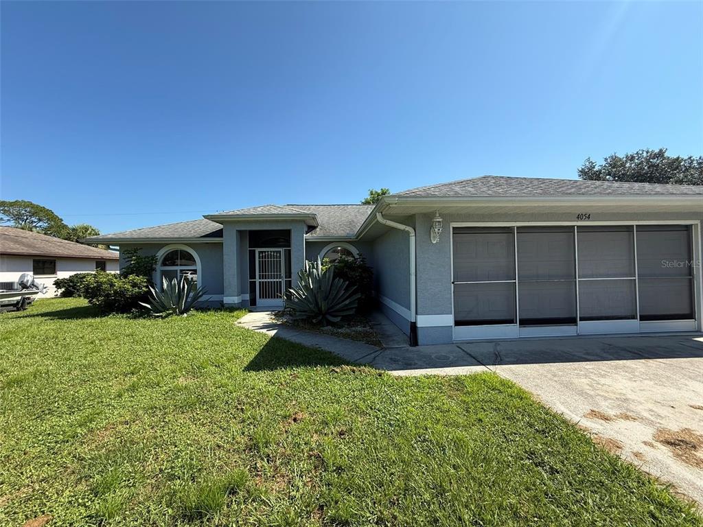 A single-story house with a gray exterior, a screened garage, and a front walkway — 4054 ALLURE LANE, NORTH PORT, FL