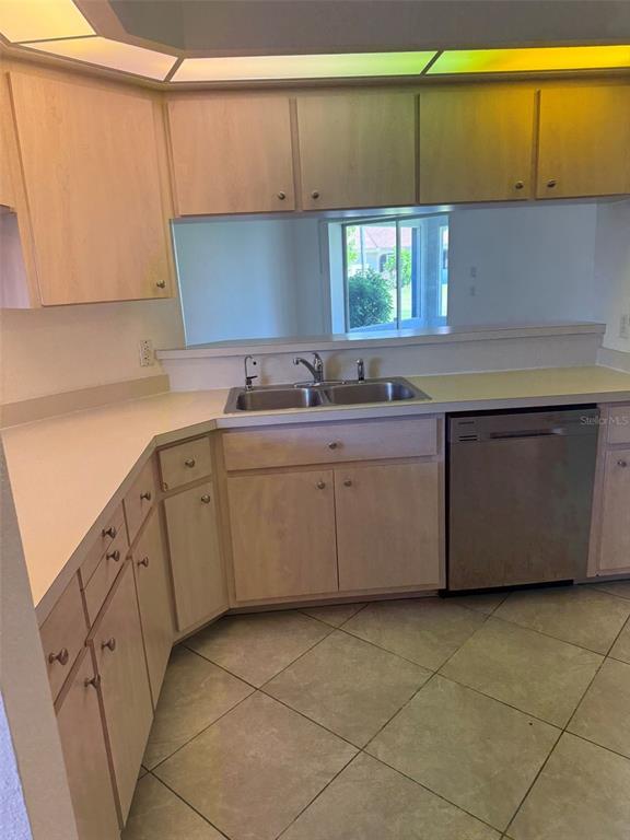 A kitchen features light wood cabinets, a double sink, and a stainless steel dishwasher — 4054 ALLURE LANE, NORTH PORT, FL