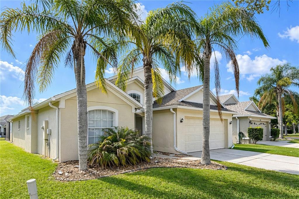 A single-story beige house with a two-car garage and three palm trees in the front — 2281 OAKINGTON STREET, WINTER GARDEN, FL