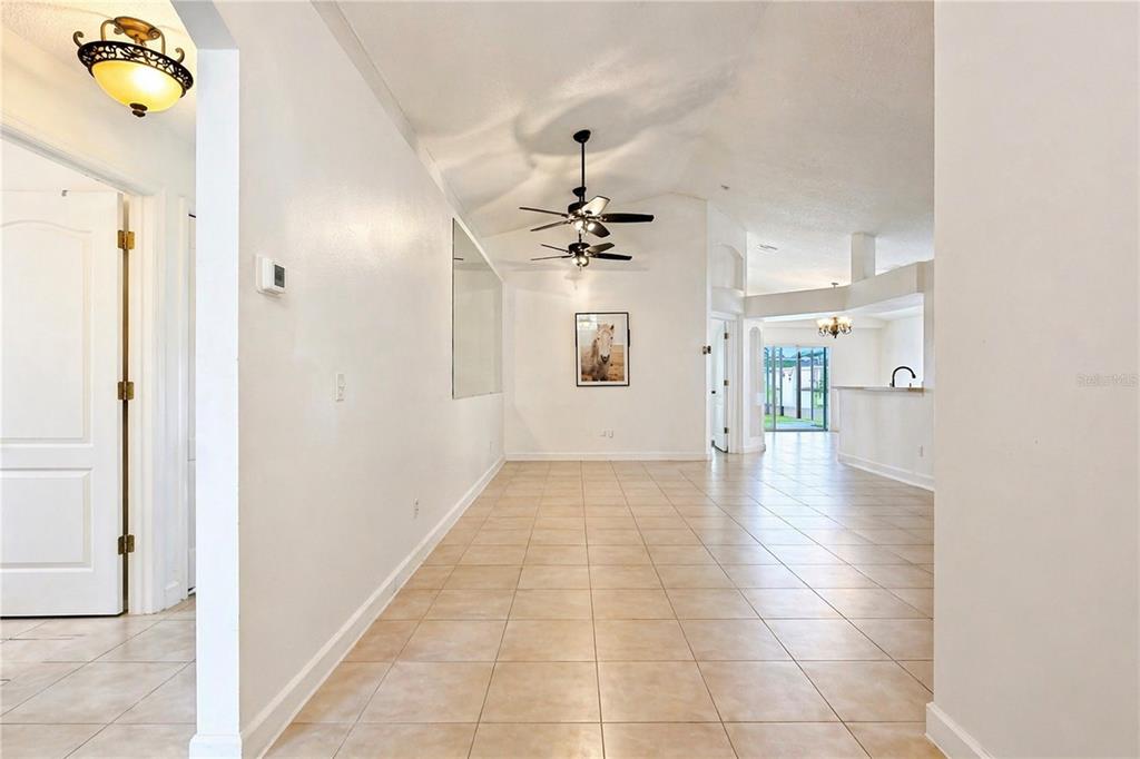 A bright, tiled hallway leads to an open living area with a vaulted ceiling — 2281 OAKINGTON STREET, WINTER GARDEN, FL