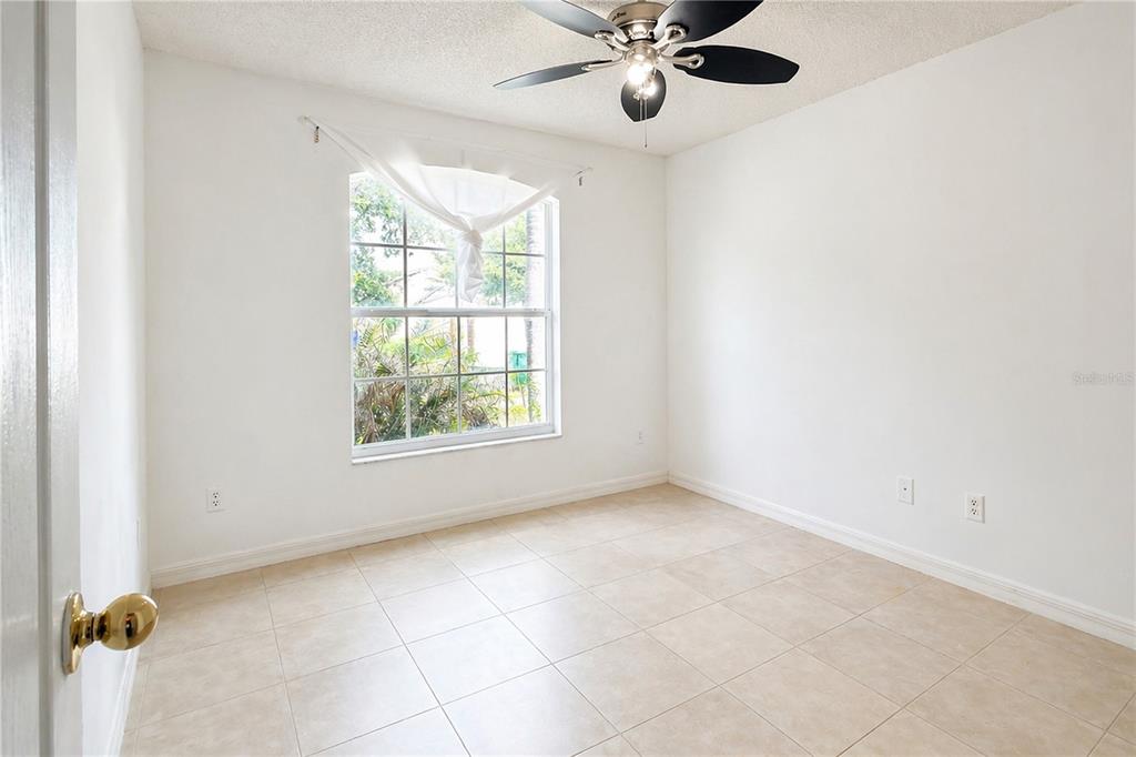 An empty bedroom features white walls, tile flooring, a ceiling fan, and a single window — 2281 OAKINGTON STREET, WINTER GARDEN, FL