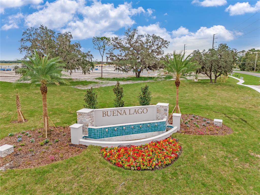 An exterior view of a community entrance sign for Buena Lago with landscaping and palm trees — 3519 MALAWI TRAIL, ST CLOUD, FL