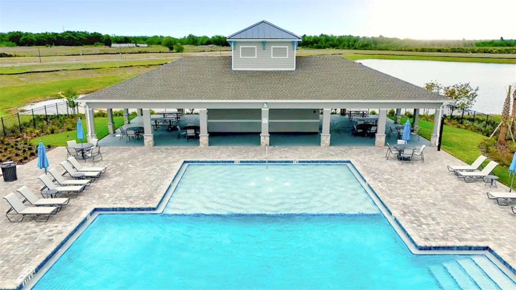 An aerial view shows a swimming pool with a sun shelf beside a covered pavilion — 3519 MALAWI TRAIL, ST CLOUD, FL