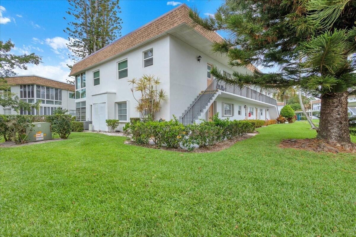 A two-story white apartment building with an exterior staircase and a green lawn — 2950 SE Ocean Boulevard # 1, Stuart FL 34996, STUART, FL