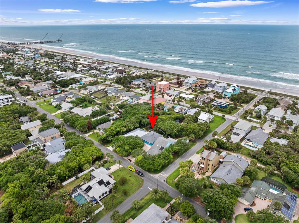 An aerial view shows a coastal neighborhood with a red arrow pointing to a house — 1339 S DAYTONA AVENUE, FLAGLER BEACH, FL
