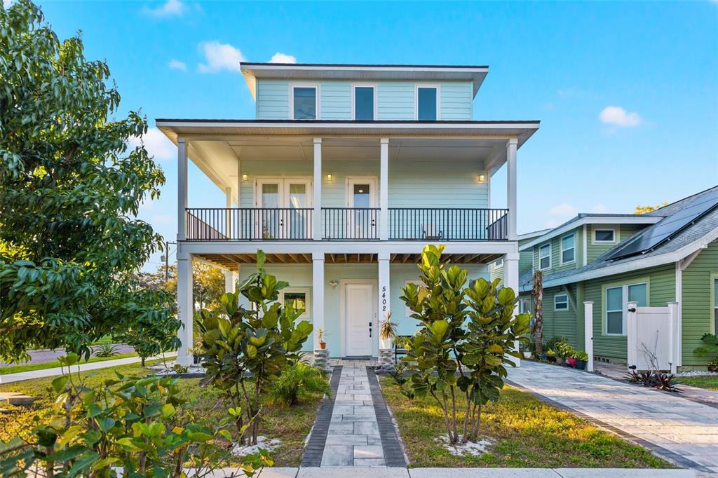 A light blue two-story house with a front porch, balcony, and a paved walkway — 5402 31ST AVENUE S, GULFPORT, FL