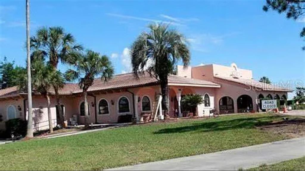 A single-story, peach-colored building with a tile roof and palm trees in front — 1532 W SCHWARTZ BOULEVARD, LADY LAKE, FL