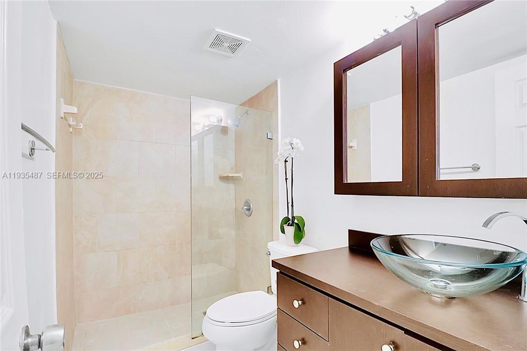 A bathroom features a glass-enclosed shower, a vessel sink vanity, and a white toilet — 1065 S Flagler Ave # 701, Pompano Beach FL 33060, POMPANO BEACH, FL
