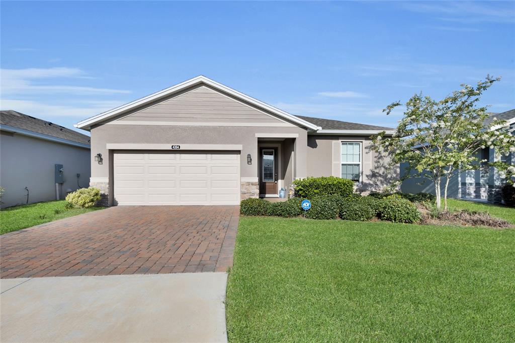 A single-story house with a brick paver driveway, a two-car garage, and a front lawn — 4394 NW 54TH TERRACE, OCALA, FL