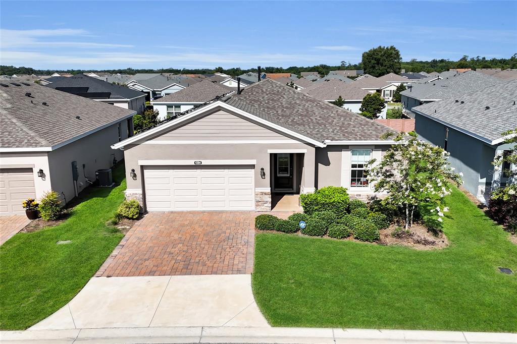 A single-story suburban house features a brick driveway, a two-car garage, and landscaped front yard — 4394 NW 54TH TERRACE, OCALA, FL