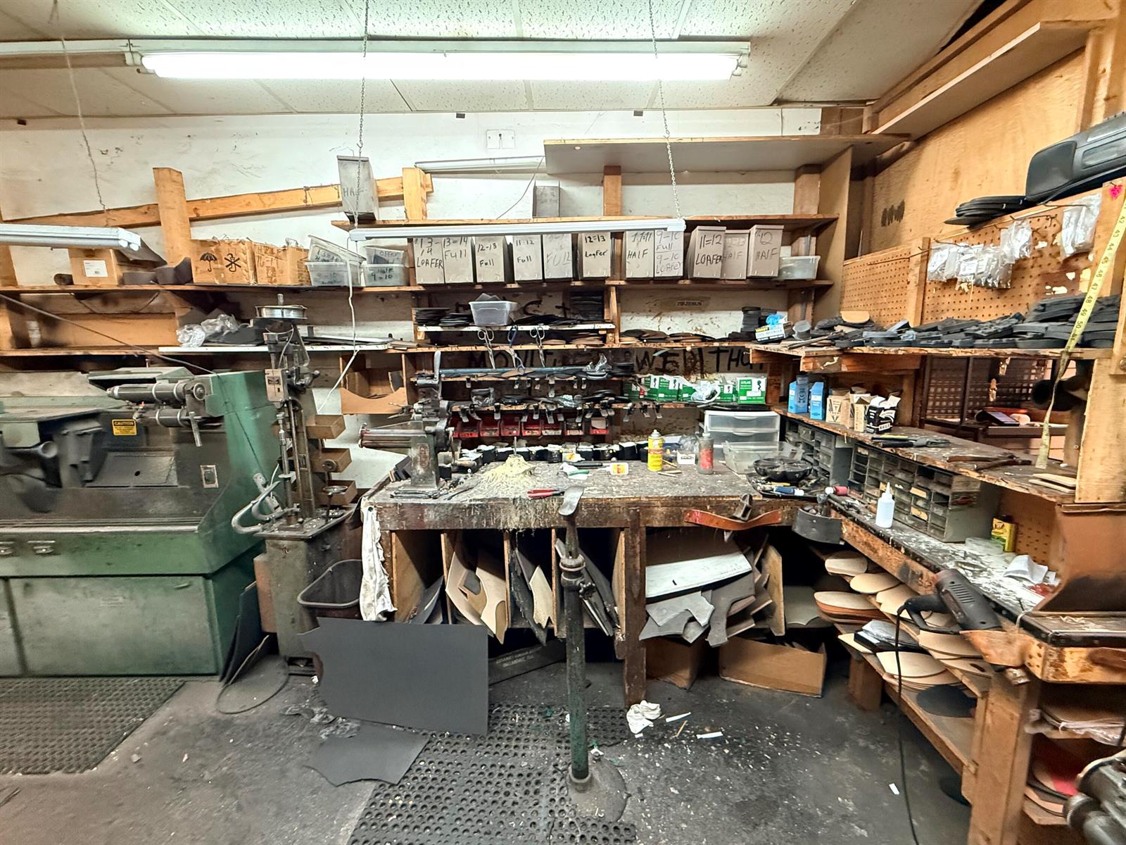 A cluttered workshop features a workbench, industrial machinery, and shelves filled with labeled storage boxes — 417 N State Road 7 # 417, Margate FL 33063, MARGATE, FL