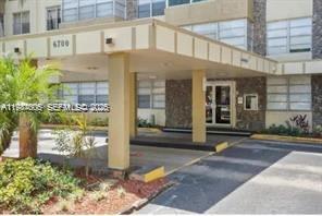 The exterior of a multi-story building features a covered entrance with a beige canopy — 6700 Cypress Rd # 409, Plantation FL 33317, PLANTATION, FL