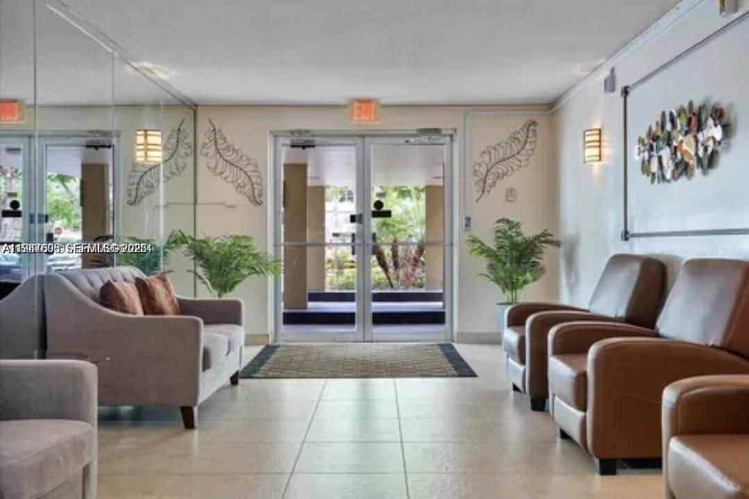 A lobby area features a glass entrance, tile flooring, a sofa, and several armchairs — 6700 Cypress Rd # 409, Plantation FL 33317, PLANTATION, FL