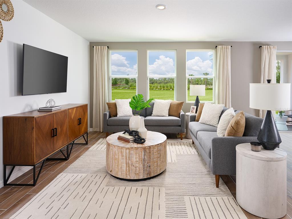 A living room features a wooden media console, gray sofas, and a round coffee table — 706 IMPALA ROAD, LAKE ALFRED, FL