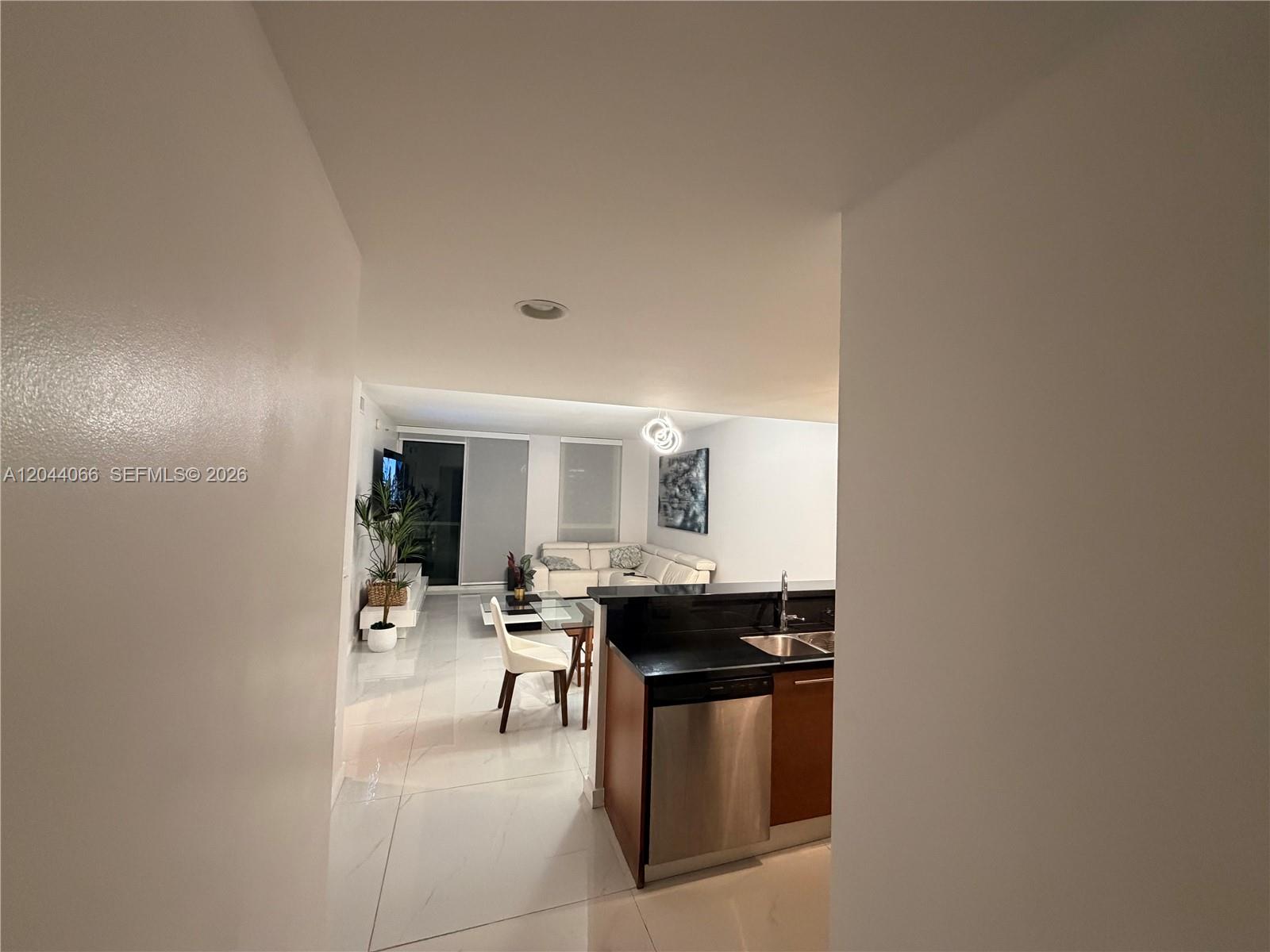 A view from a hallway looks into an open-concept living area with white tile floors — 253 NE 2nd St # 1204, Miami FL 33132, MIAMI, FL