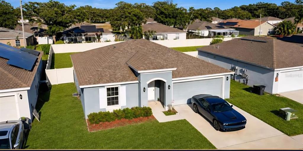 An aerial view shows a single-story house with a gray exterior, brown roof, and driveway — 3417 YARIAN DRIVE, HAINES CITY, FL