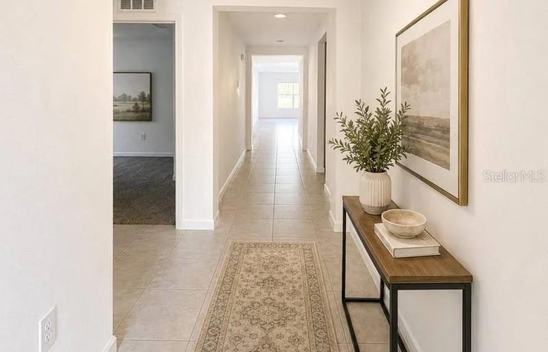 A hallway with tile flooring, a console table, and a runner rug leads to another room — 3417 YARIAN DRIVE, HAINES CITY, FL