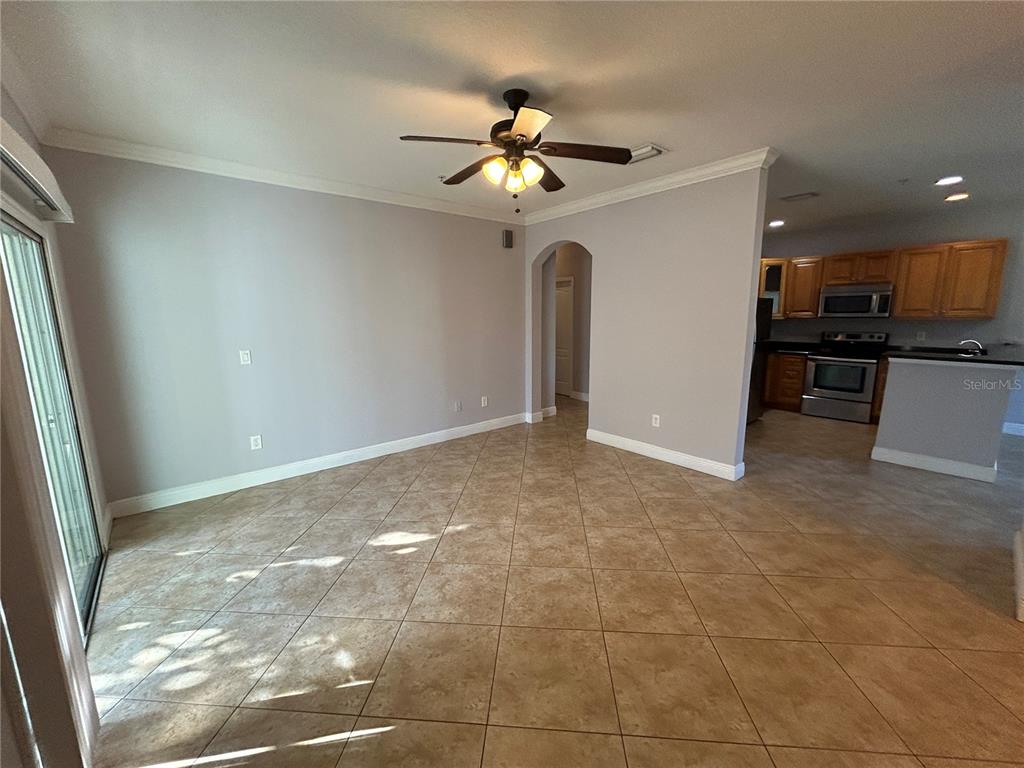 An open-concept living area features light gray walls, tile flooring, and an adjacent kitchen — 3721 S LAKE ORLANDO PARKWAY UNIT 7, ORLANDO, FL