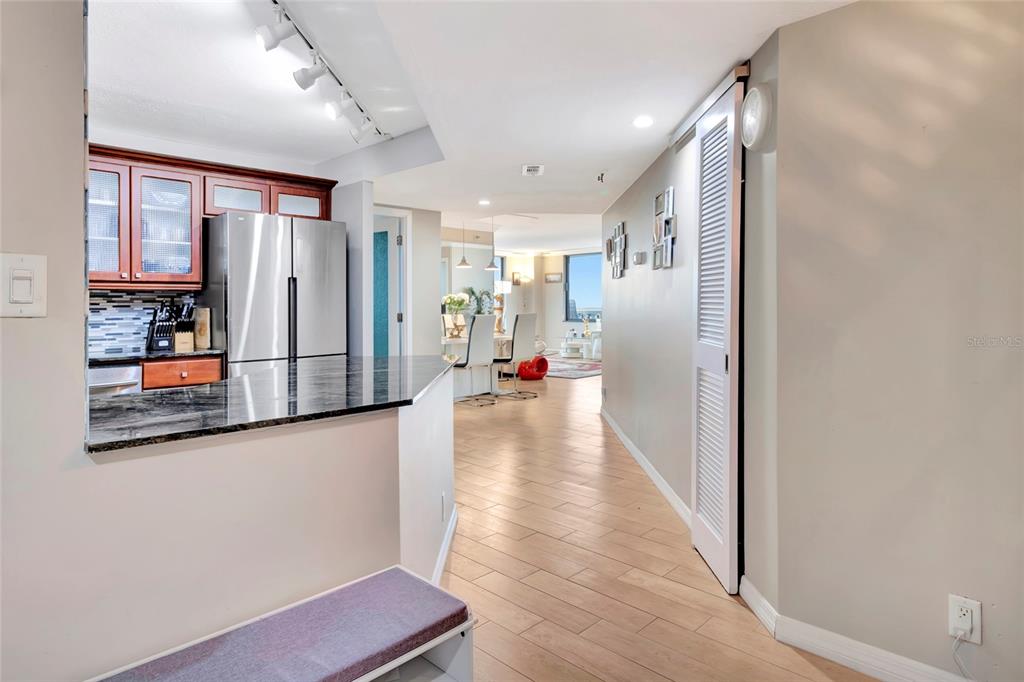 A kitchen with dark wood cabinets and granite countertops opens into a dining area — 400 E COLONIAL DRIVE UNIT 1609, ORLANDO, FL