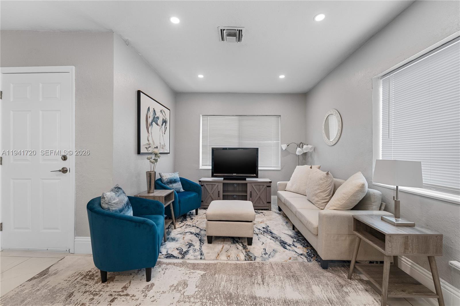 A living room features a beige sofa, two blue armchairs, and a television console — 2227 Cody St, Hollywood FL 33020, HOLLYWOOD, FL