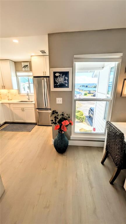 A kitchen with white cabinets and a stainless steel refrigerator overlooks a view of water — 958 SANDPIPER CIRCLE UNIT 958, BRADENTON, FL