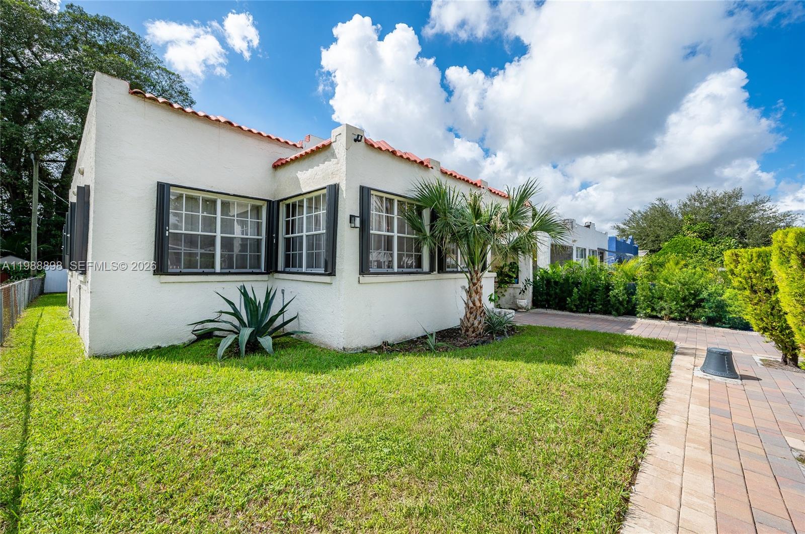 A white stucco house with a red tile roof sits on a grassy lawn — 1844 NW 47th St, Miami FL 33142, MIAMI, FL