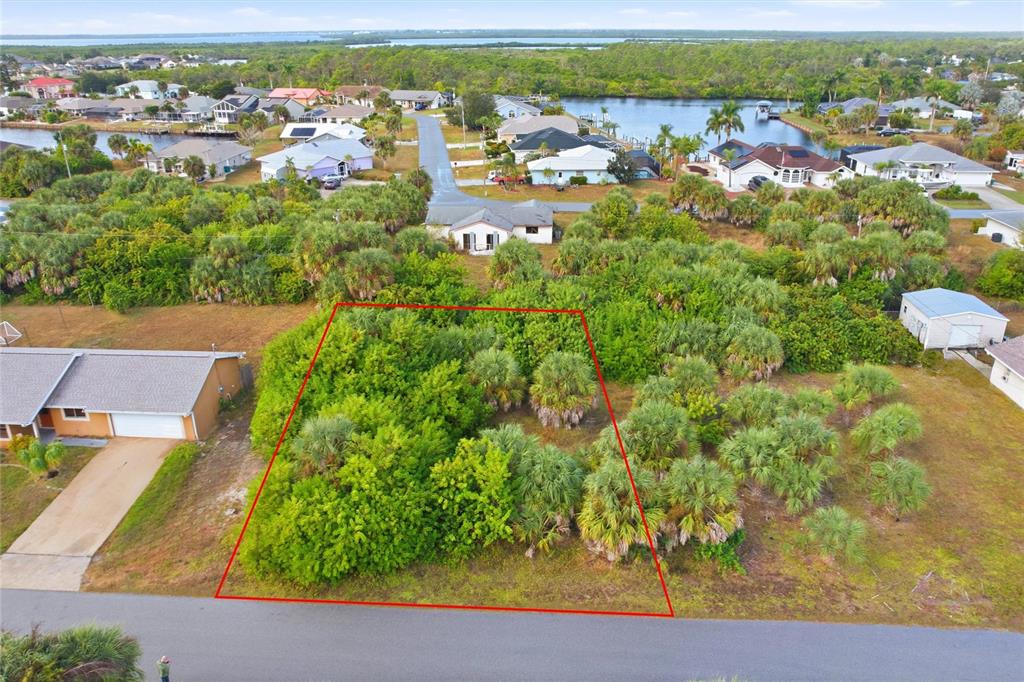 An aerial view shows a vacant, wooded residential lot outlined in red along a paved road — 4081 ROSE ARBOR CIRCLE, PORT CHARLOTTE, FL