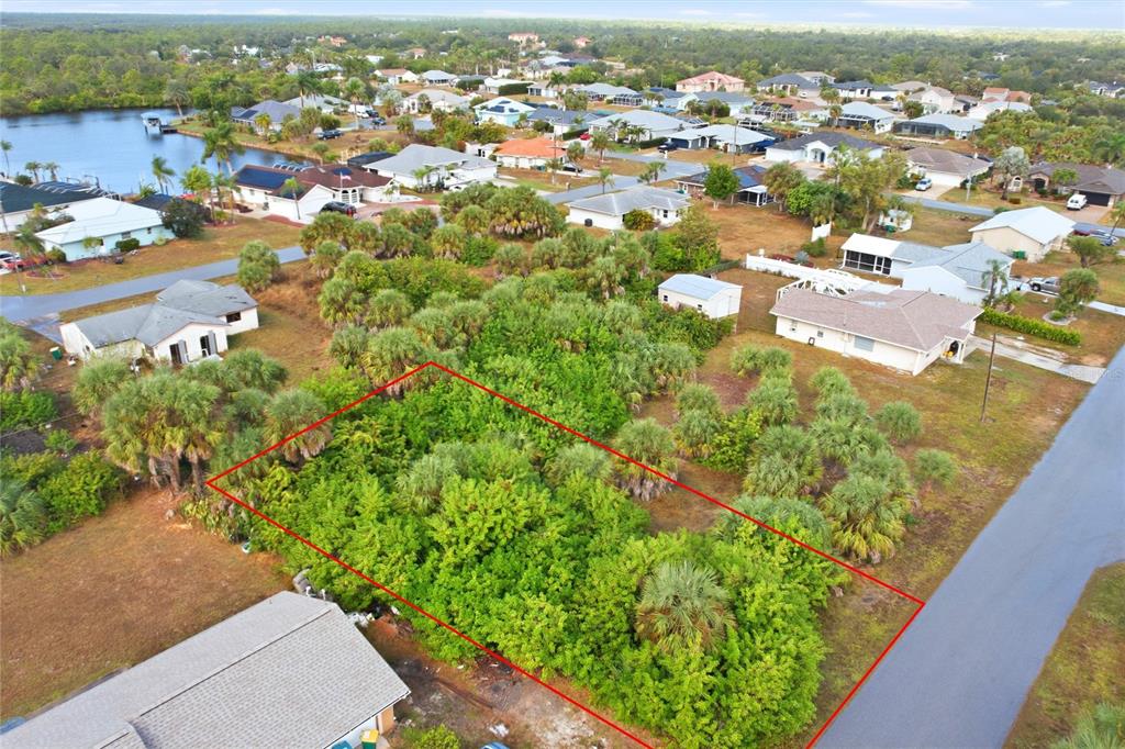 An aerial view shows a rectangular, tree-covered vacant lot outlined in red between residential houses — 4081 ROSE ARBOR CIRCLE, PORT CHARLOTTE, FL
