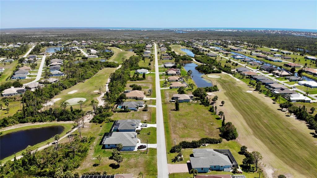 An aerial view shows a residential neighborhood with houses situated along a golf course — 89 PINE VALLEY PLACE, ROTONDA WEST, FL
