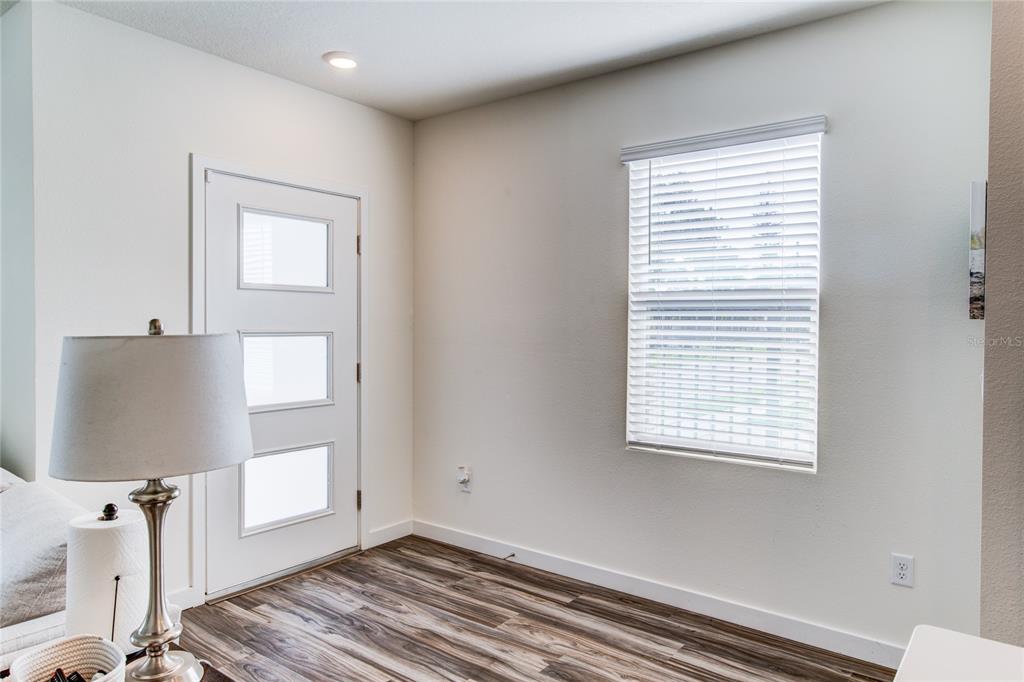 An entryway features a white door with three glass panels, wood-look flooring, and a window — 214 E CHURCH AVENUE, LONGWOOD, FL