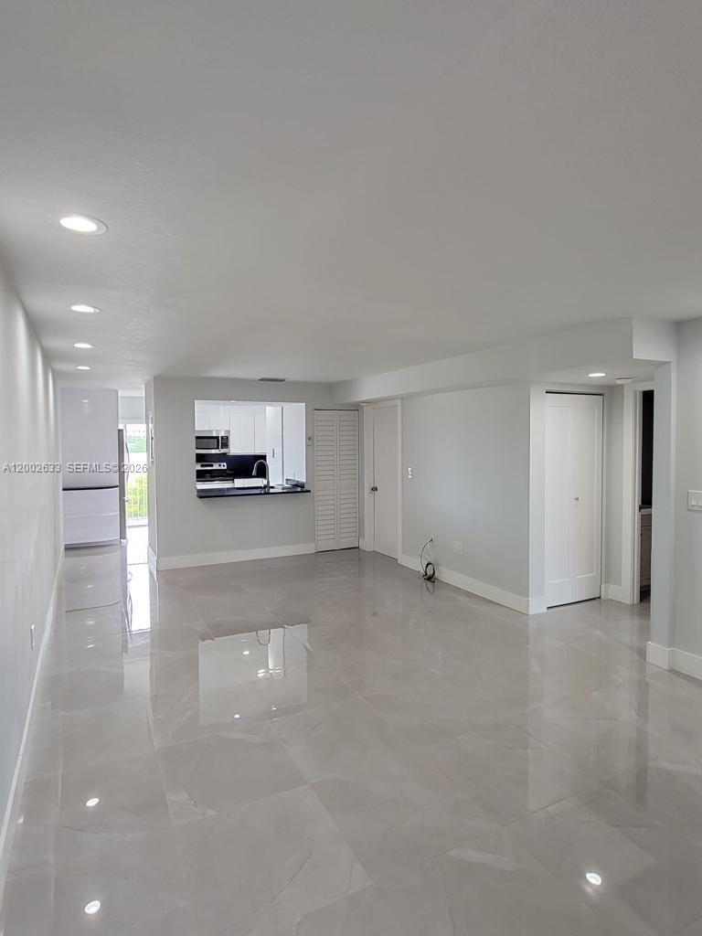 An open-concept living area features light gray walls, white trim, and glossy tile flooring — 199 SW 12th Ave # C, Miami FL 33130, MIAMI, FL