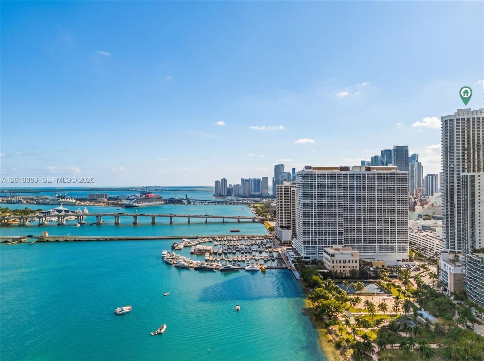 An aerial view shows a marina, a bridge, and high-rise buildings along the coast — 1750 N Bayshore Dr # 1407, Miami FL 33132, MIAMI, FL