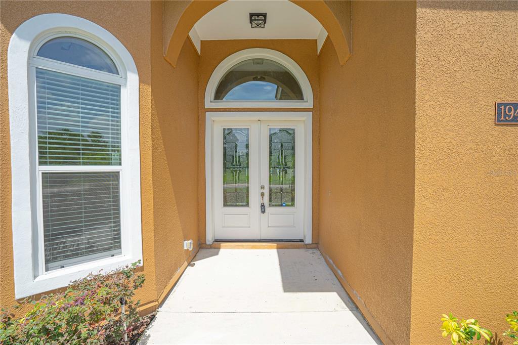 The exterior entrance features a double door with glass inserts under an arched portico — 1943 SIPES AVENUE, SANFORD, FL