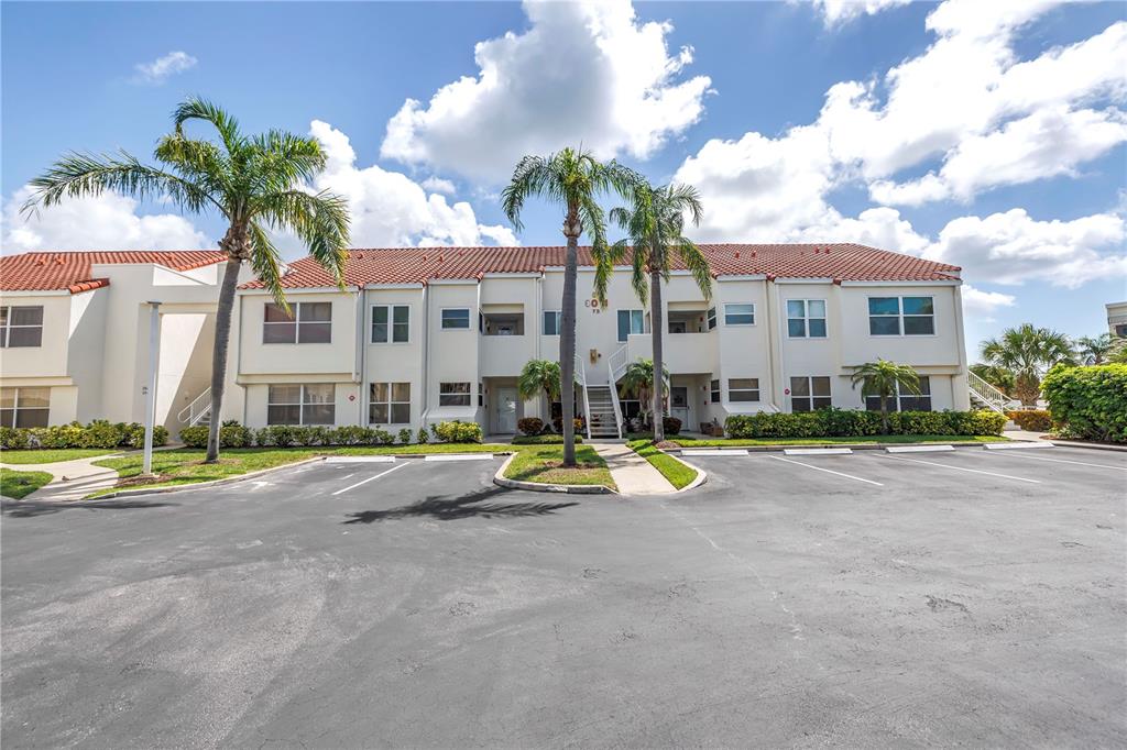 A two-story apartment building with a tiled roof and palm trees in a parking lot — 6011 BAHIA DEL MAR BOULEVARD UNIT 158, ST PETERSBURG, FL