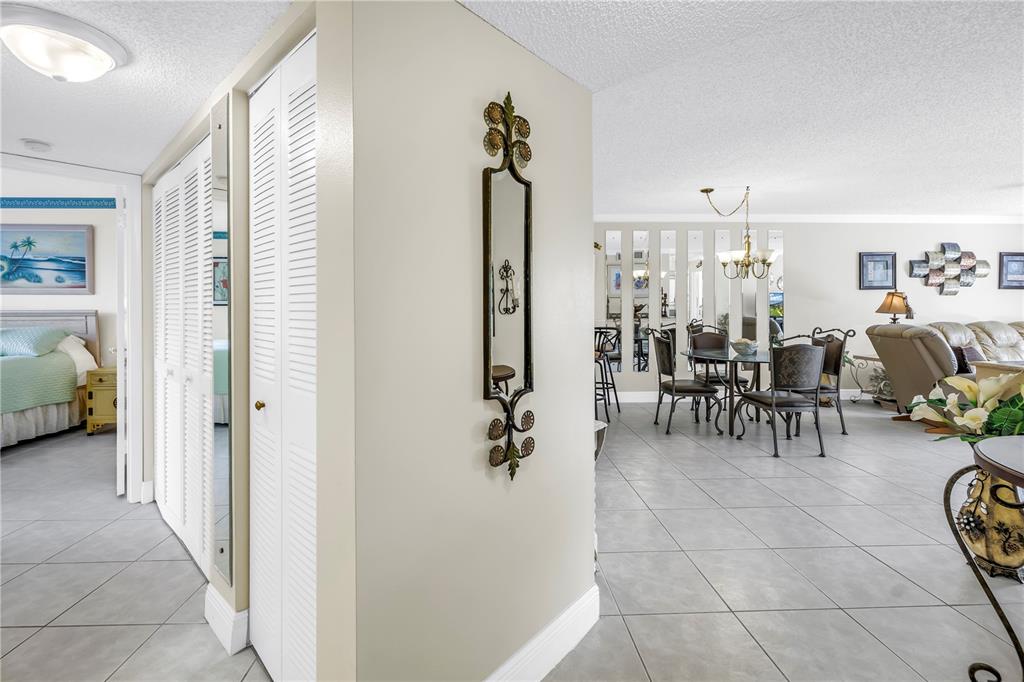 A view from a hallway looking into a dining area and living room with tile floors — 6011 BAHIA DEL MAR BOULEVARD UNIT 158, ST PETERSBURG, FL