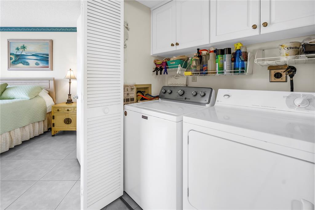 A laundry closet with a washer and dryer is located next to a bedroom — 6011 BAHIA DEL MAR BOULEVARD UNIT 158, ST PETERSBURG, FL