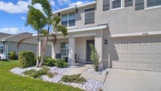 A two-story house with a beige stucco exterior, a single-car garage, and a palm tree — 16747 SUNBURST LAKE STREET, WIMAUMA, FL