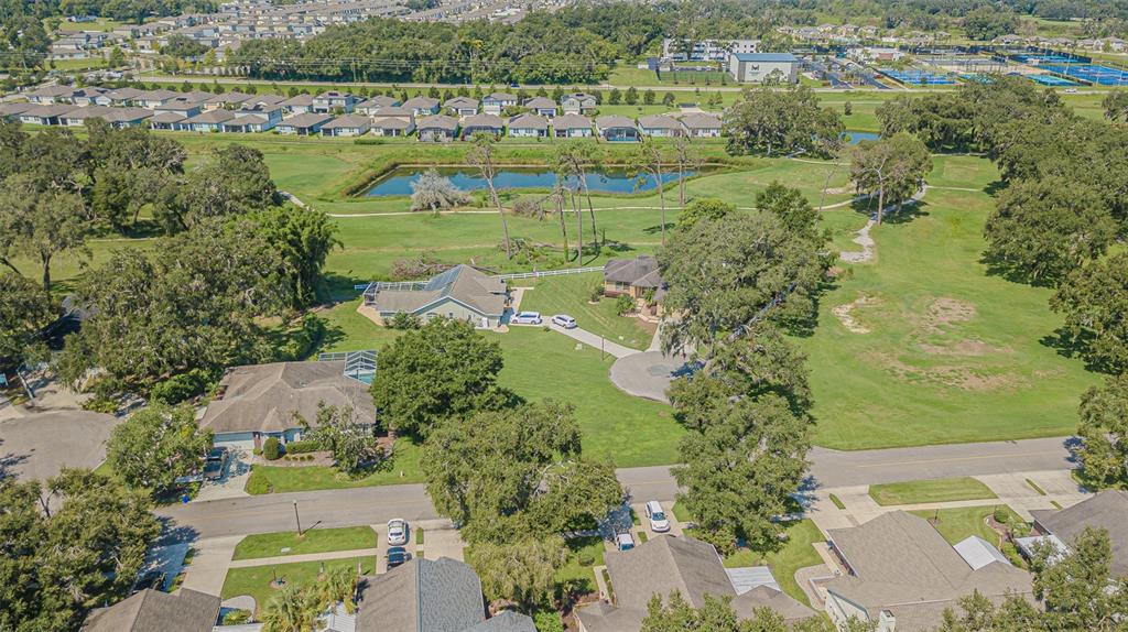 An aerial view shows several suburban houses, a pond, and green lawns in a neighborhood — BRENTWOOD DRIVE, ZEPHYRHILLS, FL